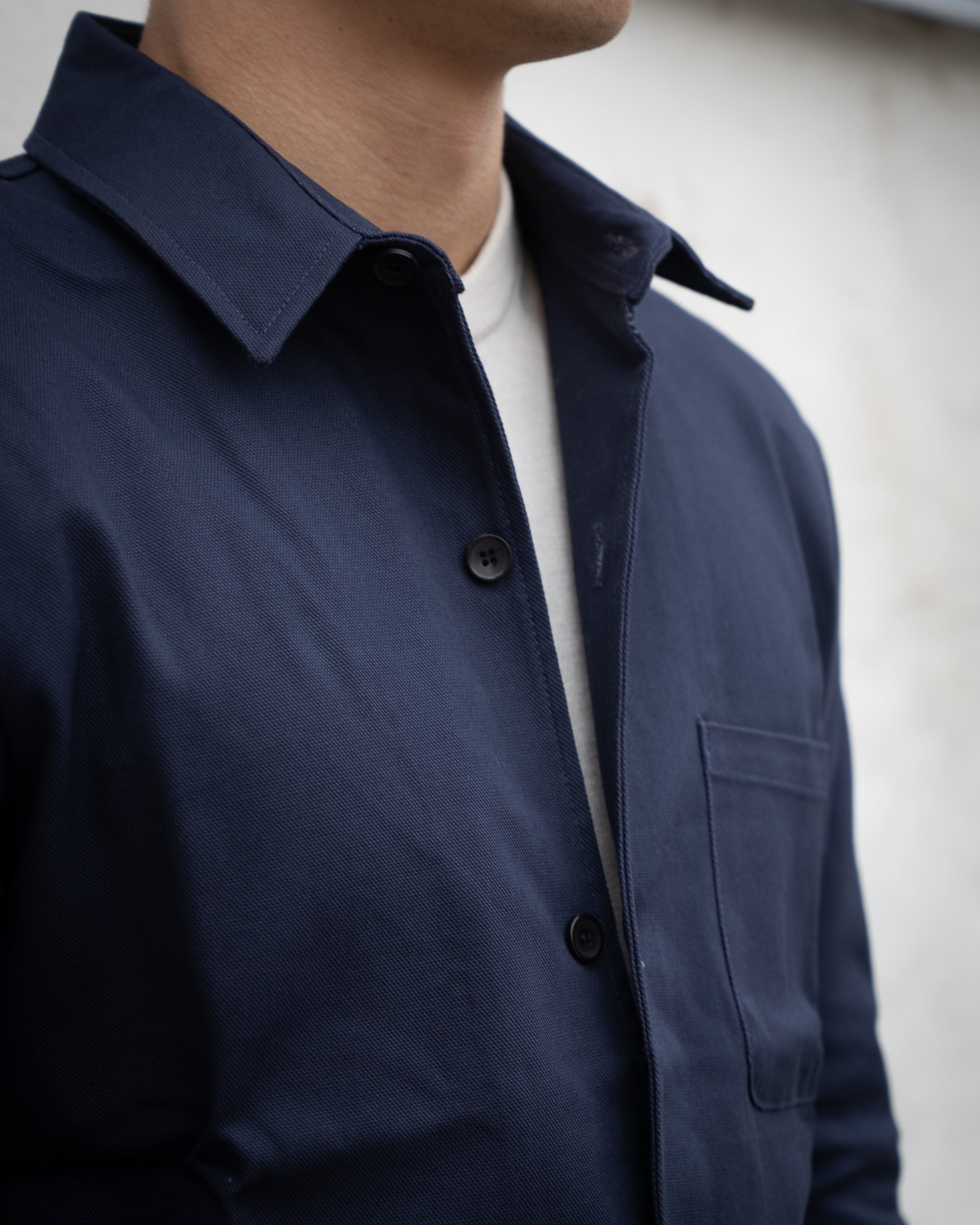 Navy blue jacket worn by a person with a neutral background
